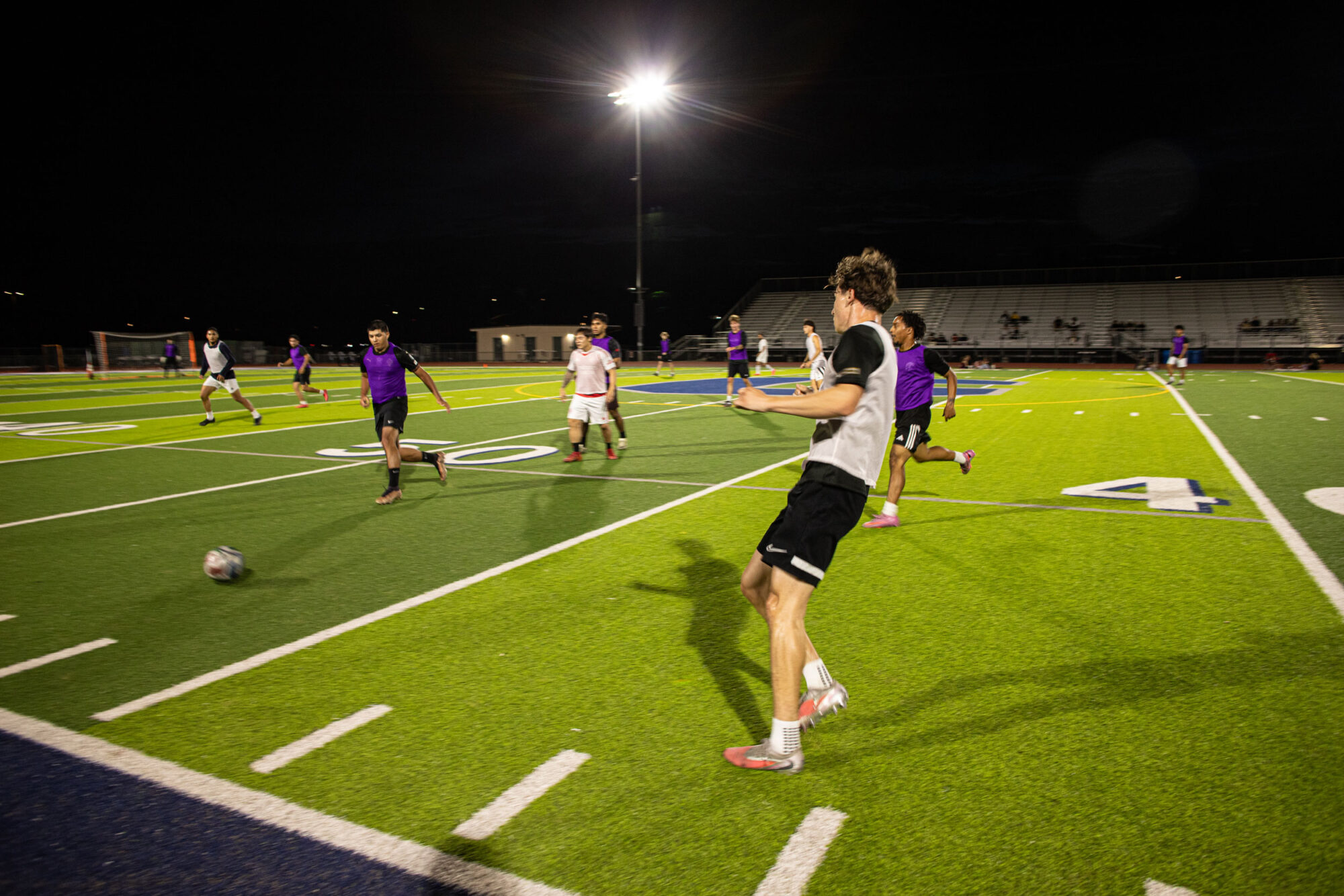 Players mid-game under the lights on a turf field in Temecula